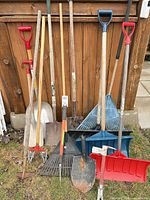 Group shot of all garden tools leaning against fence