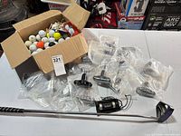 Full lot showing box of balls and tees, sealed tools, range finder, left-handed putter