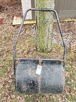 Full front view of lawn roller hanging, showing drum and handle