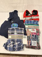 All items together: hoodie, three boxed underwear packs, pair of red slippers