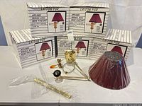 Six boxed lamps with one unboxed to show components, shades in plastic