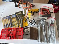 All items laid out: three corded power tools, bit sets, files and brushes