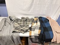 All five garments laid flat showing colours and styles