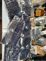 Multiple sealed packages of dark navy leisurewear on table