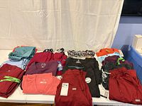 Overview of folded scrub tops and pants in various colours on table