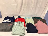 All eight folded sweaters/hoodies on table