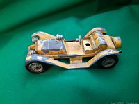 Left side view of die-cast Mercer Raceabout showing body, wheels, paint wear