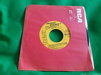 Record in sleeve front view showing label hole and RCA branding