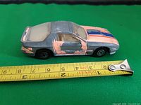 Left side view of Hot Wheels Mazda RX-7 with measuring tape showing approximately 7.5 cm length