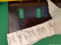 Plate partially unwrapped showing two rectangular switch openings and screw holes