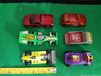 Top view of all six die-cast cars alongside ruler