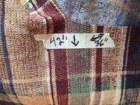 Close-up showing fabric texture and taped size label 42" x 36"