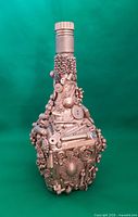 Front view of bronze steampunk-style decorated bottle