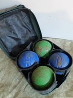 Set with four boules balls seated in plastic holder inside zip case