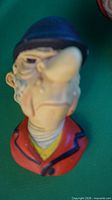 Front angle of chalkware huntsman head showing face, helmet and jacket