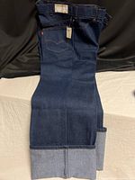 Full view of jeans with tags showing overall condition and leg style