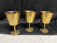 Full view of three brass goblets showing overall design