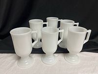 front view of all six white milk glass pedestal mugs