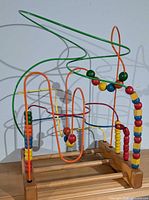 Full view of bead maze on wooden base