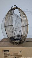 Full view of oval wicker lantern on box