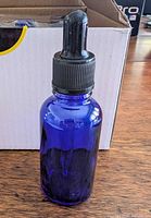 Single cobalt glass bottle with dropper assembled