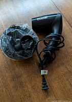 Hair dryer with plastic-wrapped diffuser and cord