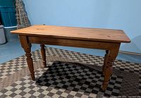 Full view of solid pine coffee table showing rectangular top and all four turned legs