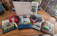 Overview of assorted lot items: cooling towel, exercise band, headphones, blank DVD spindles, weights, journal, poker chips etc.