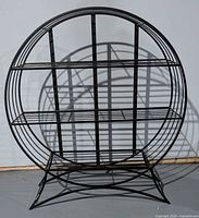 Front view of circular black metal plant stand showing overall structure