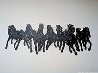 Full view of black metal cut-out horses wall decor