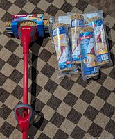 Vileda Bee Mop with six packaged refills on patterned floor