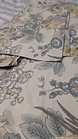 Folded duvet cover and shams showing floral and bird pattern