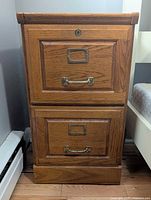 Front view of two-drawer wood file cabinet showing hardware and lock