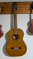 Front view of Yamaha G-231 classical guitar hanging on wall