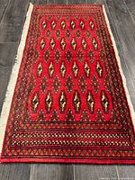 Full view of red Turkman rug showing pattern and fringe