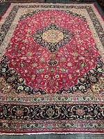 Full view of Mashhad rug showing pink field, central medallion and borders