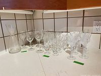 Full view of carafe, plain wine glasses, slender glasses and crystal goblets on countertop