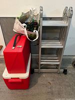 Group shot showing ladder, two red containers and bag of lights