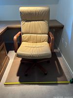 Front view of beige leather office chair on chair mat