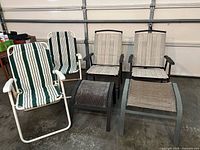 Three patio chairs and two ottomans grouped on garage floor