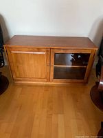 Front view of wood TV stand with solid and glass doors closed