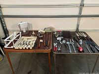 Overview of both tables showing entire lot of utensils, flatware and pitcher