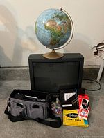 Group shot showing globe, TV, camera bag and games