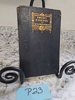 Front cover showing title, author, gilt design, and wear