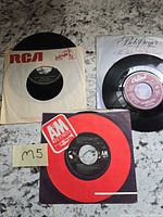 Overview of three 45 RPM records with sleeves