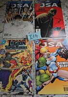 All four comic books fanned out showing covers and issue titles