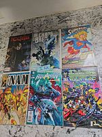 Front covers of all six comic books laid out on countertop