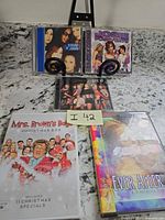 All five items laid out: two DVDs, one DVD box set, three CDs