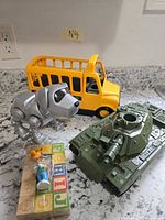 Group shot showing bus, robotic dog, tank, packaged figure