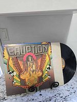 Front album jacket on stand with vinyl partly visible